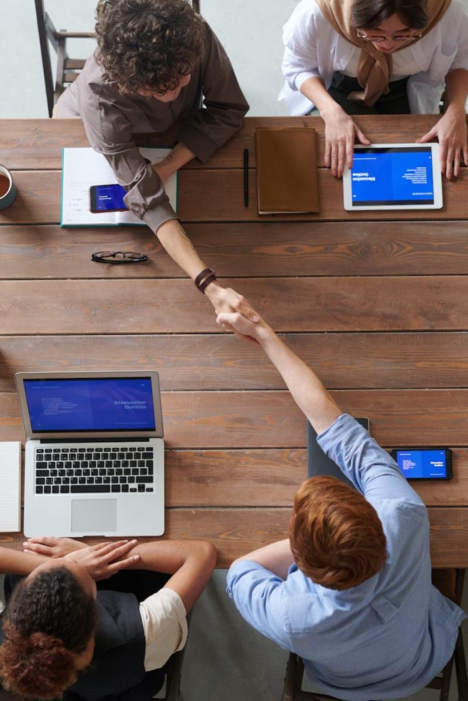 aerospace Overhead view of colleagues in a work meeting using laptops and tablets, emphasizing teamwork and technology.